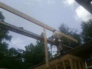 Carpenter setting a ridge beam over a new addition frame — Ice Dam Removal by Roofing Brothers in Cosby