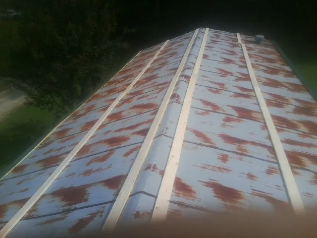 Rusted metal roof panels with new wood purlins before replacement — Storm Damage Roof Repair in Cosby by Roofing Brothers