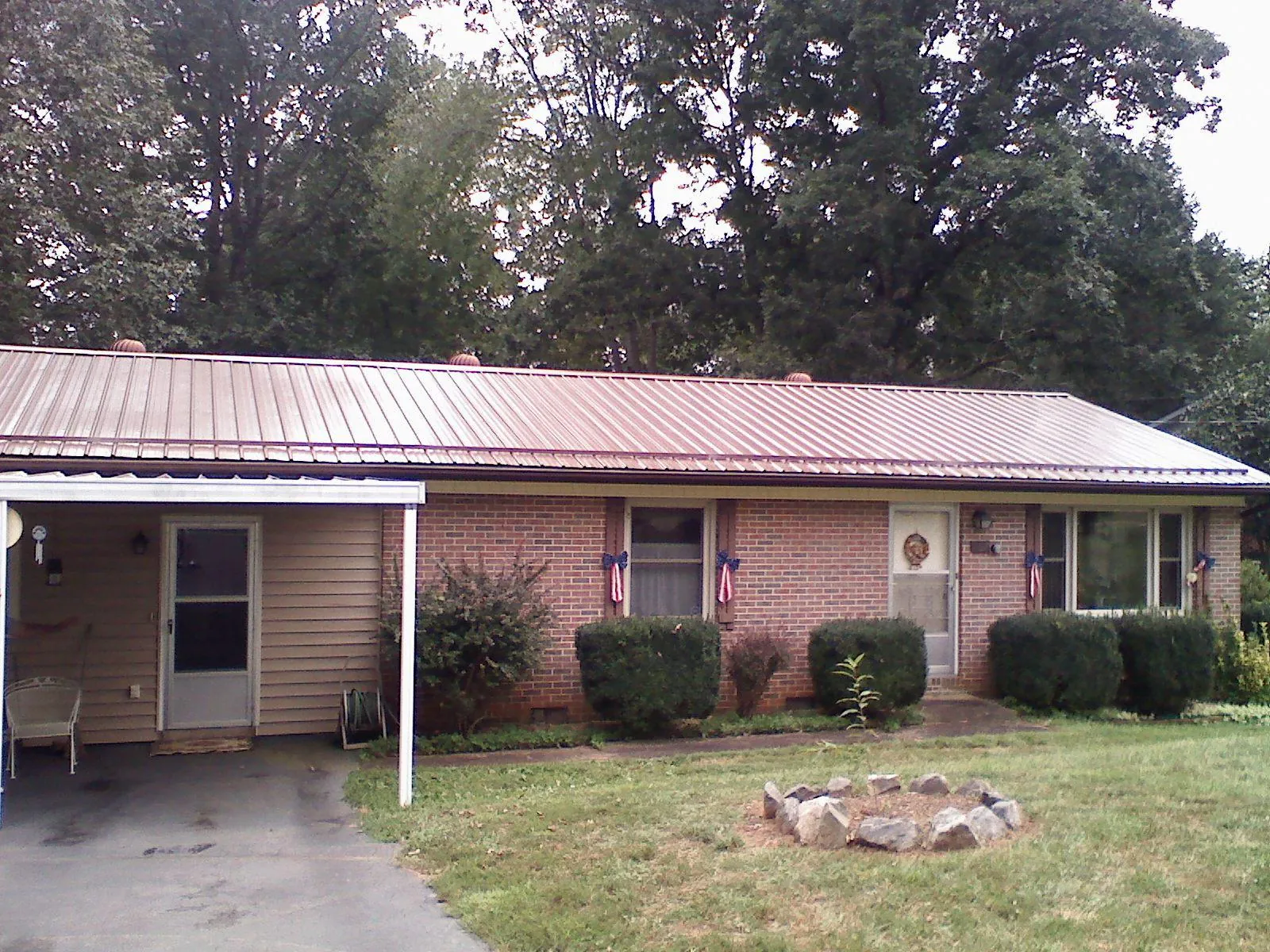 Bronze metal roof and carport on a brick ranch home — Roof Repair work by our crew in Cosby